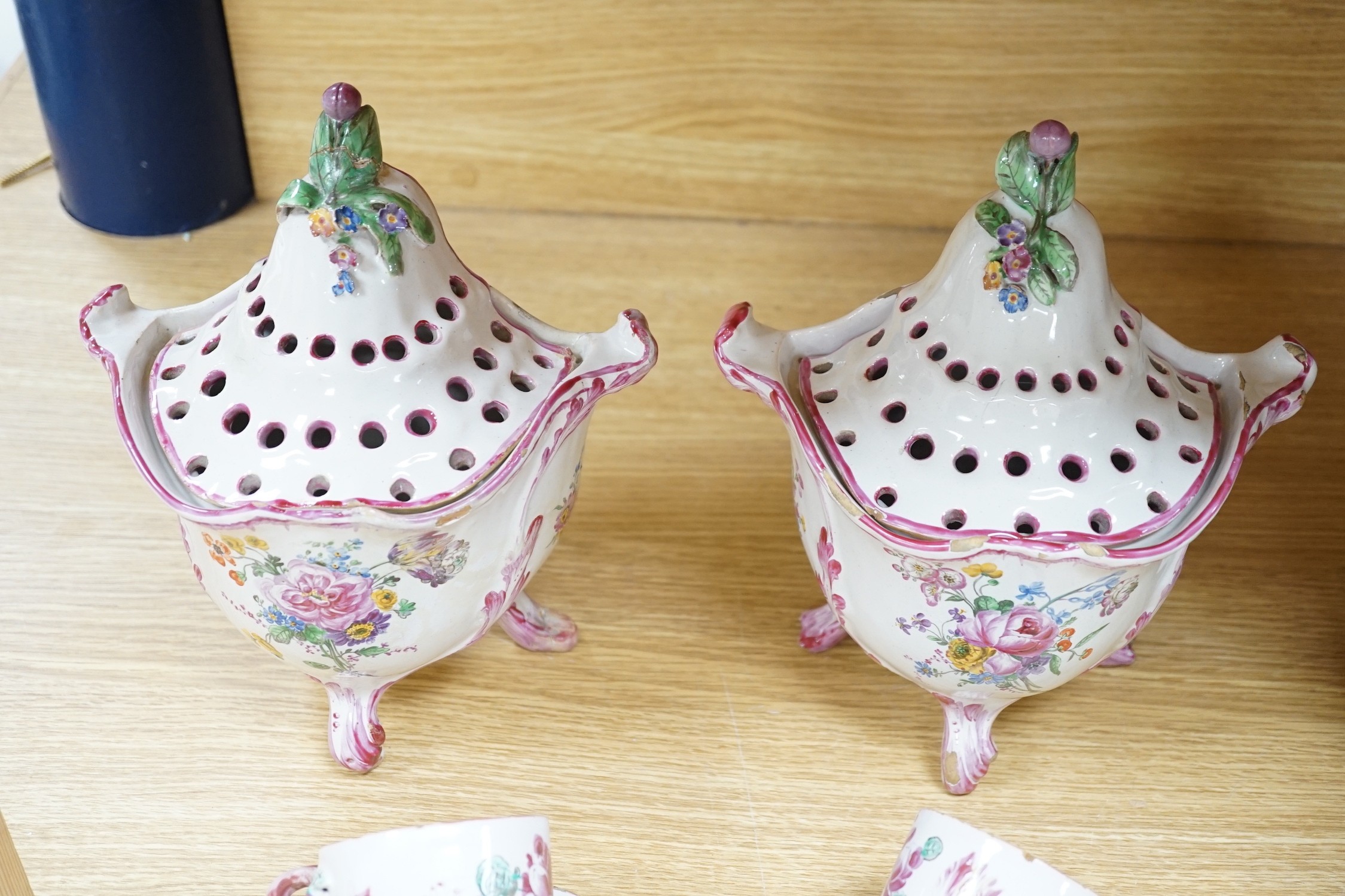 A group of of French faience pottery including a pair of pot pourri vases and covers, a tureen with integral stand, cover, ladle and four coffee cups and saucers